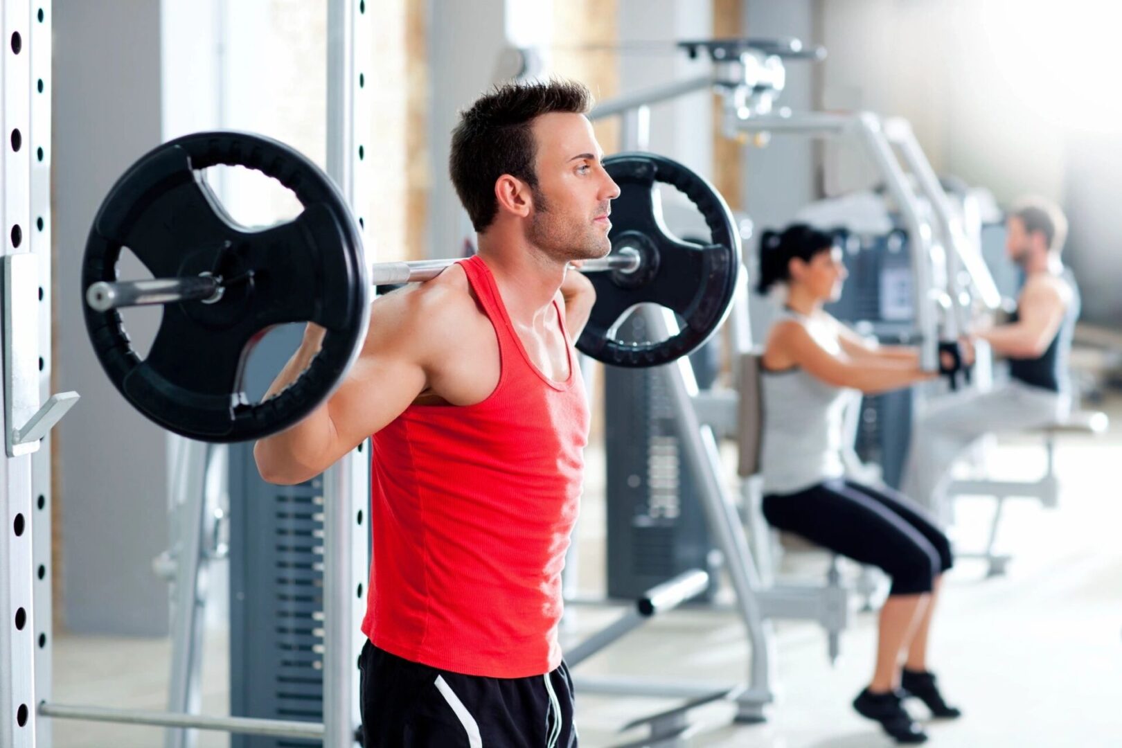 A man holding two large black barbells in his hands.